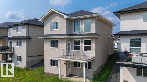 Two-story residence with a stucco exterior, dark shingle roofing, and multiple windows - 9331 181 Avenue Nw, Edmonton, AB - Outdoor