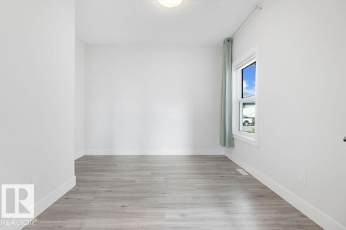 Bright interior with a single window, overhead lighting, and wood-finish flooring - 9331 181 Avenue Nw, Edmonton, AB - Indoor Photo Showing Other Room