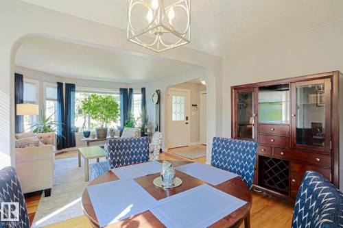 Hardwood-finish flooring throughout, featuring a curved bay window, arched doorway, and a built-in display cabinet - 12 Douziech Close, St. Albert, AB - Indoor