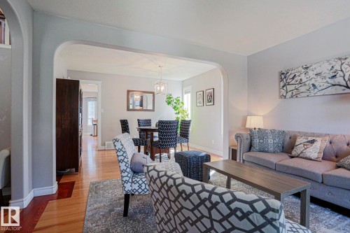 Archway entry, wood-finish flooring, recessed lighting, and a contemporary pendant light fixture - 12 Douziech Close, St. Albert, AB - Indoor Photo Showing Living Room