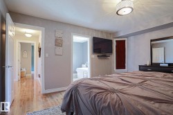 Hardwood-style flooring extends through the doorway, complemented by a contemporary ceiling light fixture - 