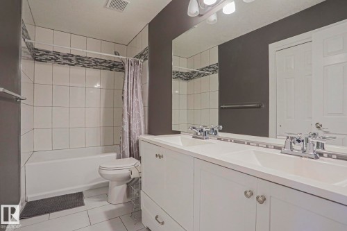 Double vanity with integrated sinks, chrome faucets, and white cabinetry - 12 Douziech Close, St. Albert, AB - Indoor Photo Showing Bathroom