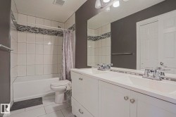 Double vanity with integrated sinks, chrome faucets, and white cabinetry - 