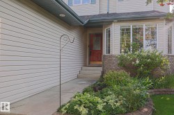 Light-colored siding exterior with a red front door - 