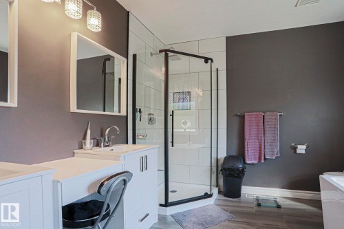 White vanity with integrated sink, rectangular mirrors, and crystal-ornamented light fixtures - 12 Douziech Close, St. Albert, AB - Indoor Photo Showing Bathroom