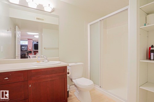 Bathroom featuring a wood-finish vanity, integrated sink, and a shower enclosure with sliding glass doors - 12 Douziech Close, St. Albert, AB - Indoor Photo Showing Bathroom