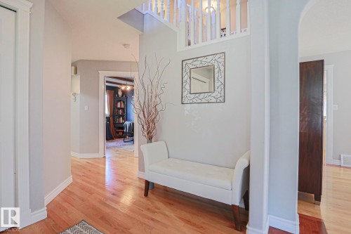 Hardwood flooring, painted walls, white trim, and a white spindle staircase - 12 Douziech Close, St. Albert, AB - Indoor Photo Showing Other Room