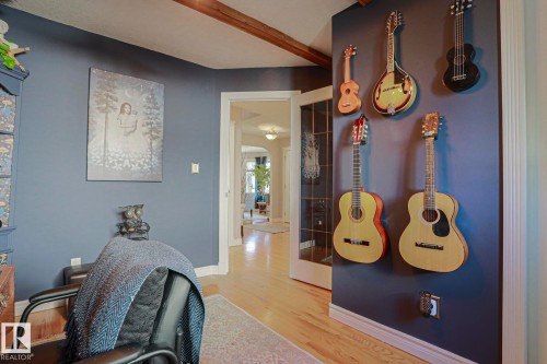 Hardwood flooring, painted walls, built-in shelving, and a wood beam ceiling accent - 12 Douziech Close, St. Albert, AB - Indoor Photo Showing Other Room