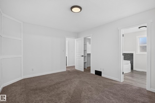 White walls with white trim, brown carpet flooring, and a built-in wall feature - 1315 Westerra Drive, Stony Plain, AB - Indoor Photo Showing Other Room