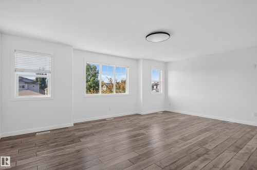 Bright room featuring wood-finish flooring, white walls, and multiple windows - 1315 Westerra Drive, Stony Plain, AB - Indoor Photo Showing Other Room