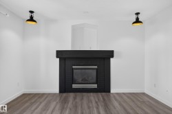 Modern fireplace with a dark surround and mantel, set against white walls - 