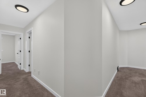 Modern hallway featuring recessed ceiling lighting, clean white drywall finishes, and neutral carpet flooring throughout - 1315 Westerra Drive, Stony Plain, AB - Indoor Photo Showing Other Room