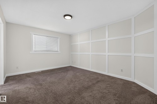 Textured carpeting, board and batten wall accent, window with blinds, recessed lighting fixture - 1315 Westerra Drive, Stony Plain, AB - Indoor Photo Showing Other Room