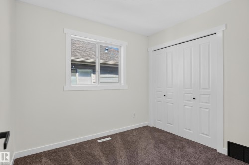 Neutral-toned walls, white trim, and brown carpet flooring - 1315 Westerra Drive, Stony Plain, AB - Indoor Photo Showing Other Room