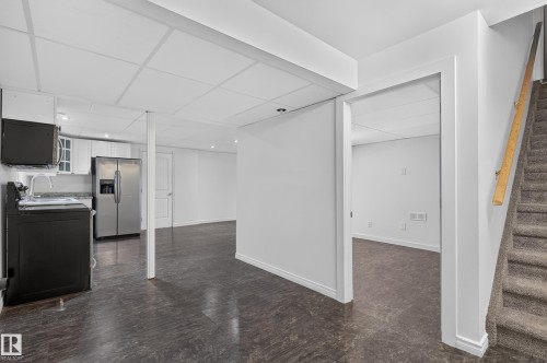 Kitchenette with white cabinetry, stainless steel refrigerator, and dark countertops - 1315 Westerra Drive, Stony Plain, AB - Indoor
