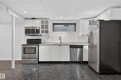Kitchen featuring white cabinetry, stainless steel appliances, a window, granite-style countertops, and recessed lighting - 1315 Westerra Drive, Stony Plain, AB - Indoor Photo Showing Kitchen
