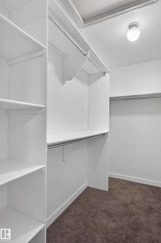 Walk-in closet featuring white shelving, multiple hanging rods, and recessed lighting - 1315 Westerra Drive, Stony Plain, AB - Indoor With Storage