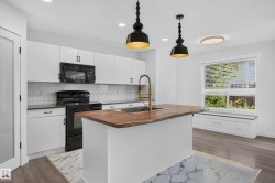 Modern kitchen featuring white cabinetry, subway tile backsplash, and a wood-finish island countertop with an integrated sink and brass-finish faucet - 