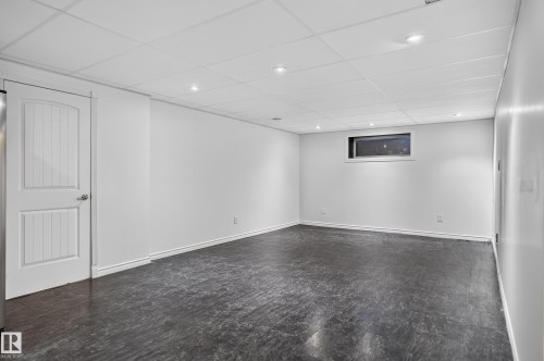 Recessed lighting illuminates this bright space featuring a drop ceiling, a horizontal window, and dark flooring - 1315 Westerra Drive, Stony Plain, AB - Indoor Photo Showing Other Room