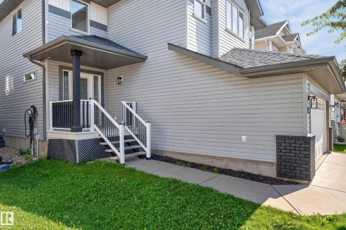 Light gray siding exterior with a covered porch entry, white railings, and a single-car garage - 1315 Westerra Drive, Stony Plain, AB - Outdoor