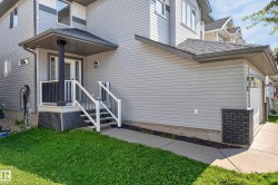 Light gray siding exterior with a covered porch entry, white railings, and a single-car garage - 