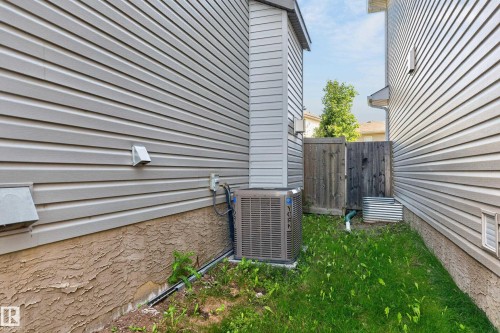 Convenient side yard featuring mature landscaping, lush lawn, and HVAC unit with accessible service area - 1315 Westerra Drive, Stony Plain, AB - Outdoor With Exterior