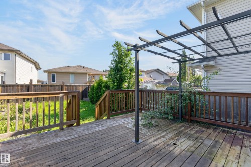 Spacious composite deck featuring a multi-level wood-finish surface with sturdy railings, anchored by a modern black metal pergola with horizontal slat roof - 1315 Westerra Drive, Stony Plain, AB - Outdoor With Deck Patio Veranda With Exterior