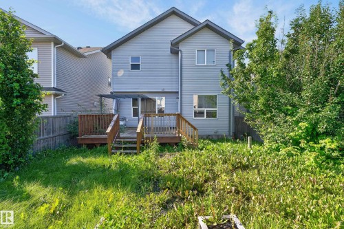 Exterior siding with multiple windows, accompanied by a wooden deck with railing and stairs - 1315 Westerra Drive, Stony Plain, AB - Outdoor With Deck Patio Veranda