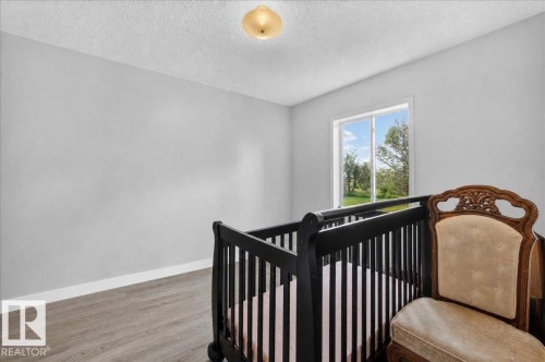 Recessed ceiling light fixture, wood-finish flooring, white trim, and a window with a natural backdrop - 543069 Range Road 191, Rural Lamont County, AB - Indoor Photo Showing Bedroom