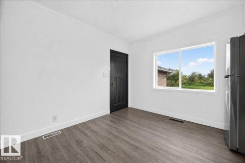 Light-filled interior featuring wood-finish flooring, crisp white walls, and a large window with a white frame - 543069 Range Road 191, Rural Lamont County, AB - Indoor Photo Showing Other Room