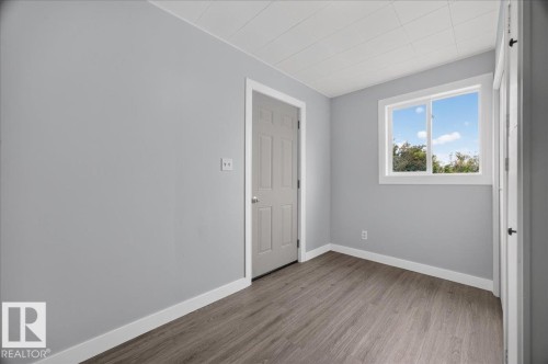 Wood-finish flooring, white trim, light gray walls, and white ceiling tiles - 543069 Range Road 191, Rural Lamont County, AB - Indoor Photo Showing Other Room