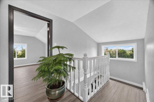Sloped ceilings with recessed lighting, wood-finish flooring, white window frames, and a white baluster railing - 543069 Range Road 191, Rural Lamont County, AB - Indoor Photo Showing Other Room