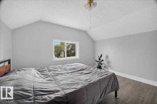 Vaulted ceiling with a flush-mount light fixture, a window with exterior views, and wood-finish flooring - 543069 Range Road 191, Rural Lamont County, AB - Indoor Photo Showing Bedroom