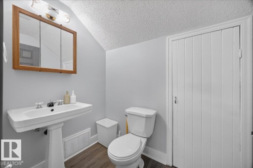 Pedestal sink with dual-handle faucet, wood-framed medicine cabinet with mirror, and wood-finish flooring - 543069 Range Road 191, Rural Lamont County, AB - Indoor Photo Showing Bathroom