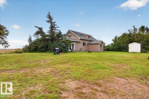 Expansive lawn surrounding a multi-level residence with dormer windows and a white storage shed - 543069 Range Road 191, Rural Lamont County, AB - Outdoor
