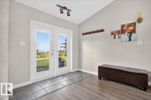 White double French doors, track lighting, neutral wall paint, wood-finish flooring, and square floor tiles - 543069 Range Road 191, Rural Lamont County, AB - Indoor Photo Showing Other Room