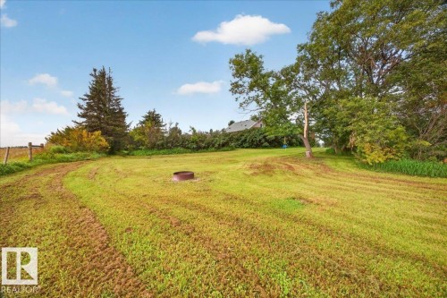 Expansive green space featuring a fire pit, mature trees, and a distant structure - 543069 Range Road 191, Rural Lamont County, AB - Outdoor With View