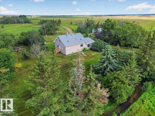 Single-story residence with light-colored siding, a dark gray shingle roof, and a wood deck with stairs - 543069 Range Road 191, Rural Lamont County, AB - Outdoor With View