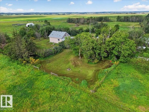 Expansive green landscape featuring a detached residence with light-colored siding, a gray shingle roof, and mature trees - 543069 Range Road 191, Rural Lamont County, AB - Outdoor With View