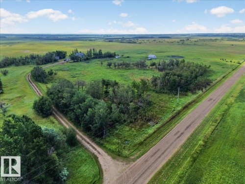Expansive green fields with natural tree coverage and multiple outbuildings - 543069 Range Road 191, Rural Lamont County, AB - Outdoor With View