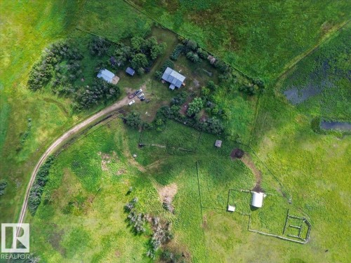 Expansive green landscape featuring multiple structures, a winding dirt road, and distinct fenced areas - 543069 Range Road 191, Rural Lamont County, AB - 