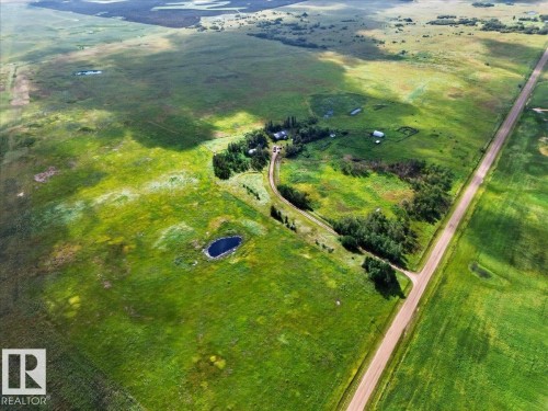 Expansive green acreage with a small pond, established treed areas, and a visible road - 543069 Range Road 191, Rural Lamont County, AB - Outdoor With View