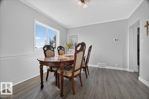 Light gray walls with white crown molding, a large window, and wood-finish flooring - 543069 Range Road 191, Rural Lamont County, AB - Indoor Photo Showing Dining Room