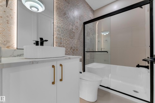 White vanity with gold-tone hardware and a countertop vessel sink - 2408 1 Avenue Sw, Edmonton, AB - Indoor