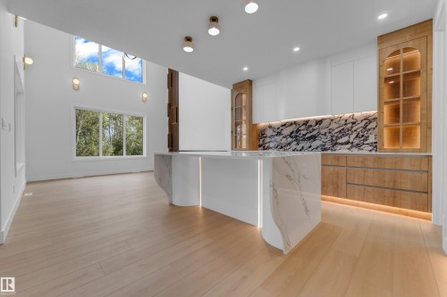High ceilings, light wood-finish flooring, and expansive windows - 2408 1 Avenue Sw, Edmonton, AB - Indoor Photo Showing Kitchen