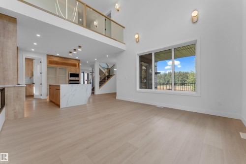 Vaulted ceilings, wood-finish flooring, quartz-finish kitchen island, built-in stainless steel appliances, and a glass-paneled loft - 2408 1 Avenue Sw, Edmonton, AB - Indoor