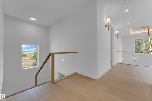 Light wood-finish flooring with recessed ceiling lighting - 2408 1 Avenue Sw, Edmonton, AB - Indoor Photo Showing Other Room