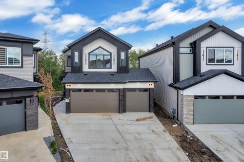 Modern exterior featuring dark siding, white vertical siding accents, and a dual garage - 2408 1 Avenue Sw, Edmonton, AB - Outdoor