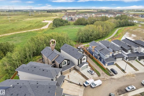 Modern residential street with contemporary homes, varied exterior finishes, and attached garages - 2408 1 Avenue Sw, Edmonton, AB - Outdoor With View