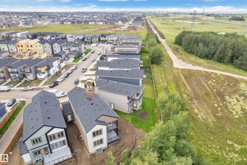 Newly constructed residential development featuring multiple detached homes with dark shingle roofs - 2408 1 Avenue Sw, Edmonton, AB - Outdoor With View